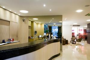 a hotel lobby with a bar and a waiting area at Pampulha Lieu Hotel in Belo Horizonte