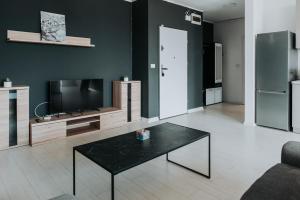 a living room with a black table and a tv at Apartament Nord One in Timişoara