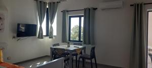 a room with a table and chairs and a window at Sa Mesaluna Naturhouse in Ilbono