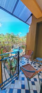 a patio with chairs and tables on a balcony at Pipas Apartment I Walk to the beach in Tamarindo