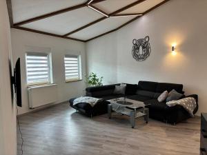 a living room with a black couch and a table at Wohlfühloase in Quiddelbach in Quiddelbach
