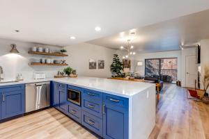 a kitchen with blue cabinets and a living room at Park Station Luxury Retreat in Park City +111 photos