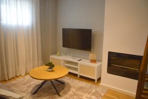a living room with a table and a flat screen tv at Casa da Tecas in Vila Nova de Gaia