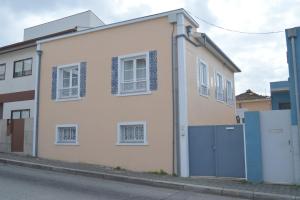 una casa bianca con porte blu su una strada di Casa da Tecas a Vila Nova de Gaia