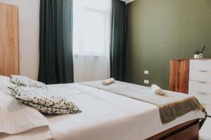 a bedroom with a large white bed with a window at Apartament Nord One in Timişoara