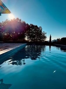 a pool of blue water with trees in the background at Villa 6 personnes avec piscine partagée in Conca