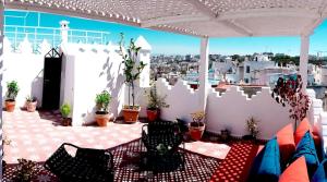 a patio with tables and chairs and a view of a city at Dar Matisse, maison de charme au cœur de Tanger in Tangier