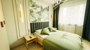 a bedroom with a bed with green sheets and a window at Apartament MARIA in Biała Podlaska