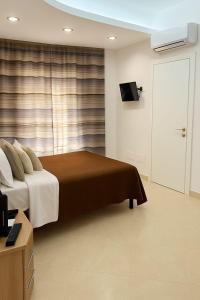 a bedroom with a bed and a window with a television at SOGNO D'ESTATE 2 in Mazara del Vallo