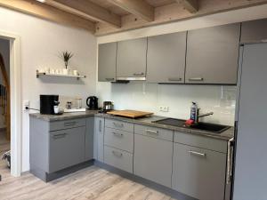 a kitchen with white cabinets and gray counters at Wohlfühloase in Quiddelbach in Quiddelbach