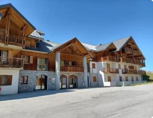 a large wooden building with a driveway in front of it at Appartement chalet à la montagne in Albiez-Montrond
