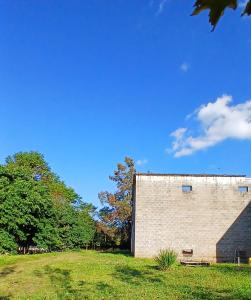 a brick building sitting in a field next to trees at Pousada IMcasa 430 in Bento Gonçalves