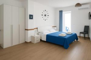 a bedroom with a blue bed and a clock on the wall at SOGNO D'ESTATE 2 in Mazara del Vallo +22 photos