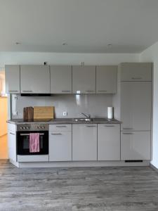 a kitchen with white cabinets and a stove top oven at Mams-Cottage-Brunhilde in Harnischdorf