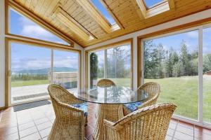 a dining room with a glass table and chairs at Lakeview Home with new hot tub - Sleeps 10 in Sandpoint