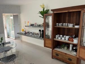 a kitchen with a shelf with dishes on it at Hotel Casabella in Chapadão do Sul