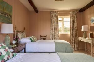 a hotel room with two beds and a window at Haybarn Cottage in Alton