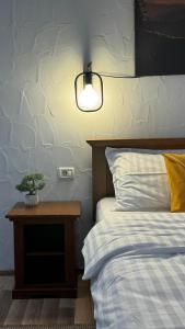 ein Schlafzimmer mit einem Bett und einem Tisch mit einer Pflanze darauf in der Unterkunft Hotel Lucy Star in Cluj-Napoca