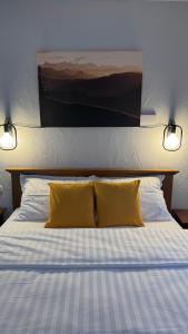 ein Bett mit zwei gelben Kissen darauf in der Unterkunft Hotel Lucy Star in Cluj-Napoca