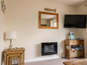 a living room with a tv and a fireplace at 49 Atlantic Reach in Newquay