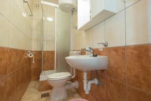 a bathroom with a toilet and a sink and a shower at Apartments&Rooms SB in Neum