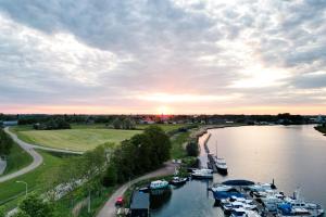 a group of boats docked in a river at sunset at The Creative Boat in Lithoijen