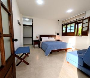 a bedroom with a bed and a couch and a chair at Oikos Casa Campestre in Pitalito
