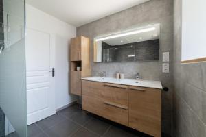 a bathroom with a sink and a mirror at Les Combettes - Terrasse, Jardin & Proche Lac in Moyrazès +12 photos