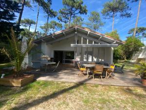 a patio with a table and chairs and a house at Villa Dreamland à Seignosse océan in Seignosse