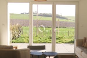 a living room with a view of a field through a glass door at GC - Idem in Wissant