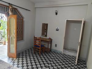 a room with a table and a chair and a door at Sidds Hospitality Inn in kolkata
