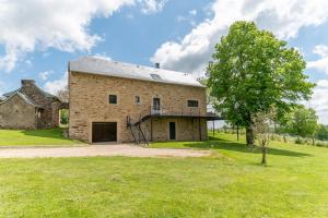 an old brick building with a tree in the yard at Les Combettes - Terrasse, Jardin & Proche Lac in Moyrazès