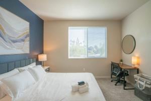 a bedroom with a large white bed and a window at Posh 2BD - Gym, Pool, Parking, W-D - Sleeps 8 in Tempe