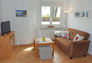 a living room with a couch and a table at schöne Ferienwohnungen im Zentrum von Rügen in Thesenvitz