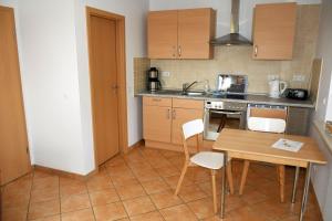a small kitchen with a wooden table and chairs at schöne Ferienwohnungen im Zentrum von Rügen in Thesenvitz +40 photos