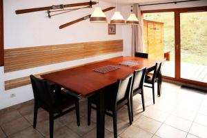 a dining room with a wooden table and black chairs at Chalet La Combe D Or - Superbe chalet 10 personnes MAE-3584 in Le Mélézet