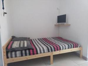 un letto di legno con un monitor sopra di Studio Grau du Roi avec piscine a Le Grau-du-Roi