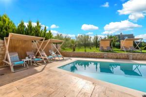 a swimming pool with chairs and a table next to a villa at Allas Villa Heated Pool in Chania Town
