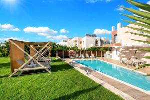 a backyard with a swimming pool and a lawn with chairs at Allas Villa Heated Pool in Chania Town