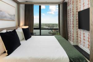 una camera da letto con un letto grande con una grande finestra di Luxury Apartments by Hyatus Downtown Boston a Boston