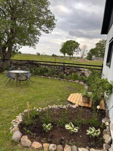 a garden with a table and chairs in the grass at Hönshuset in Köpingsvik
