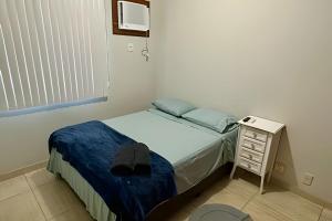 ein kleines Schlafzimmer mit einem Bett und einem Nachttisch in der Unterkunft P706 - Ar cond Garagem Solda manha in Vitória