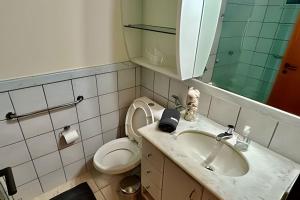 ein Badezimmer mit Waschbecken, Toilette und Spiegel in der Unterkunft P706 - Ar cond Garagem Solda manha in Vitória + 10 Fotos