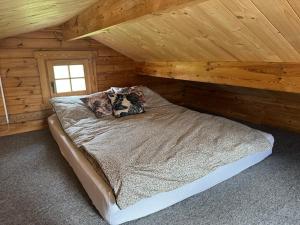 a bedroom with a bed in a wooden cabin at Domek nad Rozlewiskiem in Mielno Pyrzyckie +15 photos