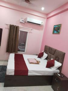 AyodhyaThe Sunrise Ayodhya Guest House的粉红色客房内的一间卧室,配有一张床