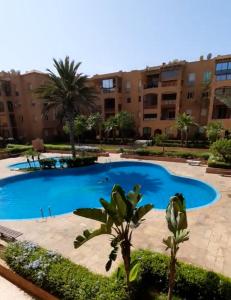 曼苏里亚Ricoflores Mansouria的建筑物前有一个大型游泳池。
