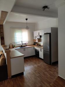 曼苏里亚Ricoflores Mansouria的厨房配有白色橱柜和黑色冰箱