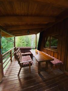a wooden deck with a table and benches on it at Lenivka in Hnilčík