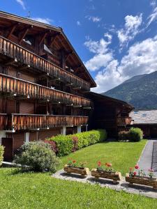 a building with some flowers in front of it at 3 Bed Apartment with Private Terrace, Communal Pool, Mont Blanc Views in Saint-Gervais-les-Bains