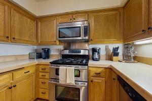 サンバレーにある4311 Fairway 9のキッチン(ステンレス製の電化製品、木製キャビネット付)